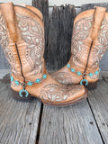 Turquoise squash blossom 6-station boot bracelet chain worn on tan tooled leather cowboy boots, full pair view
