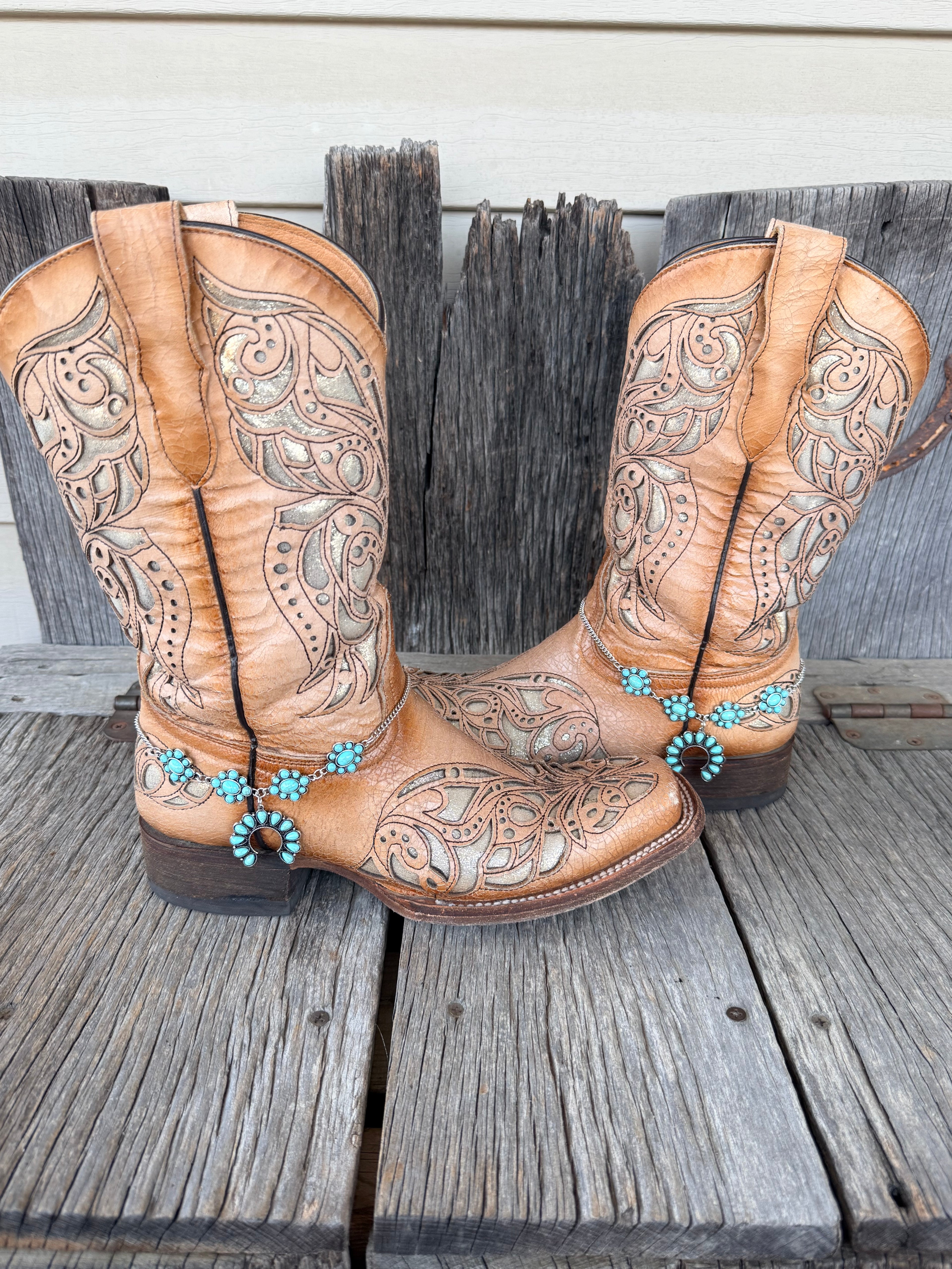 Turquoise squash blossom boot bracelet chain worn on tan tooled leather cowboy boots, full pair view
