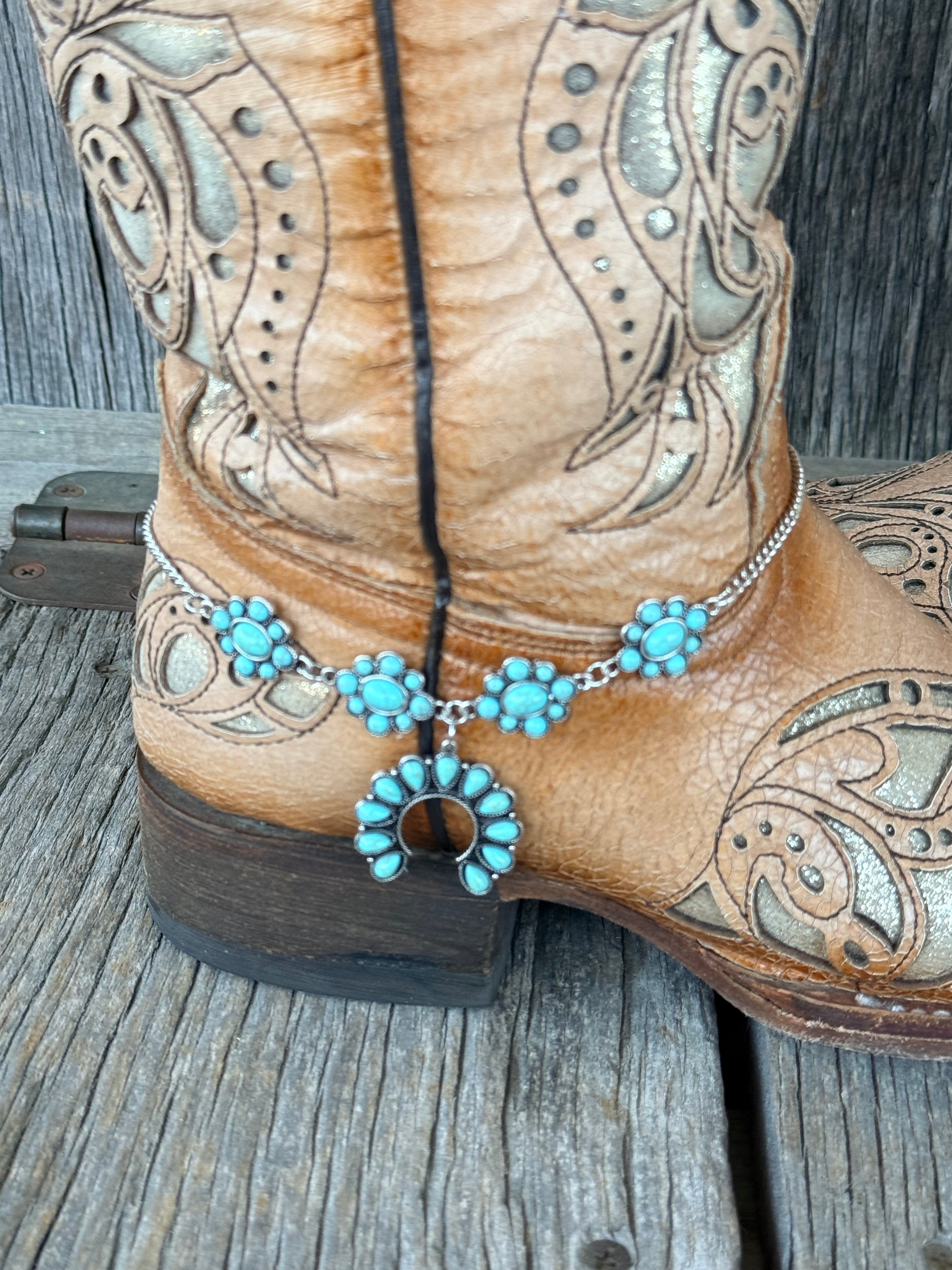 Close-up of turquoise squash blossom naja pendant and cluster rosette stations on silver chain boot bracelet
