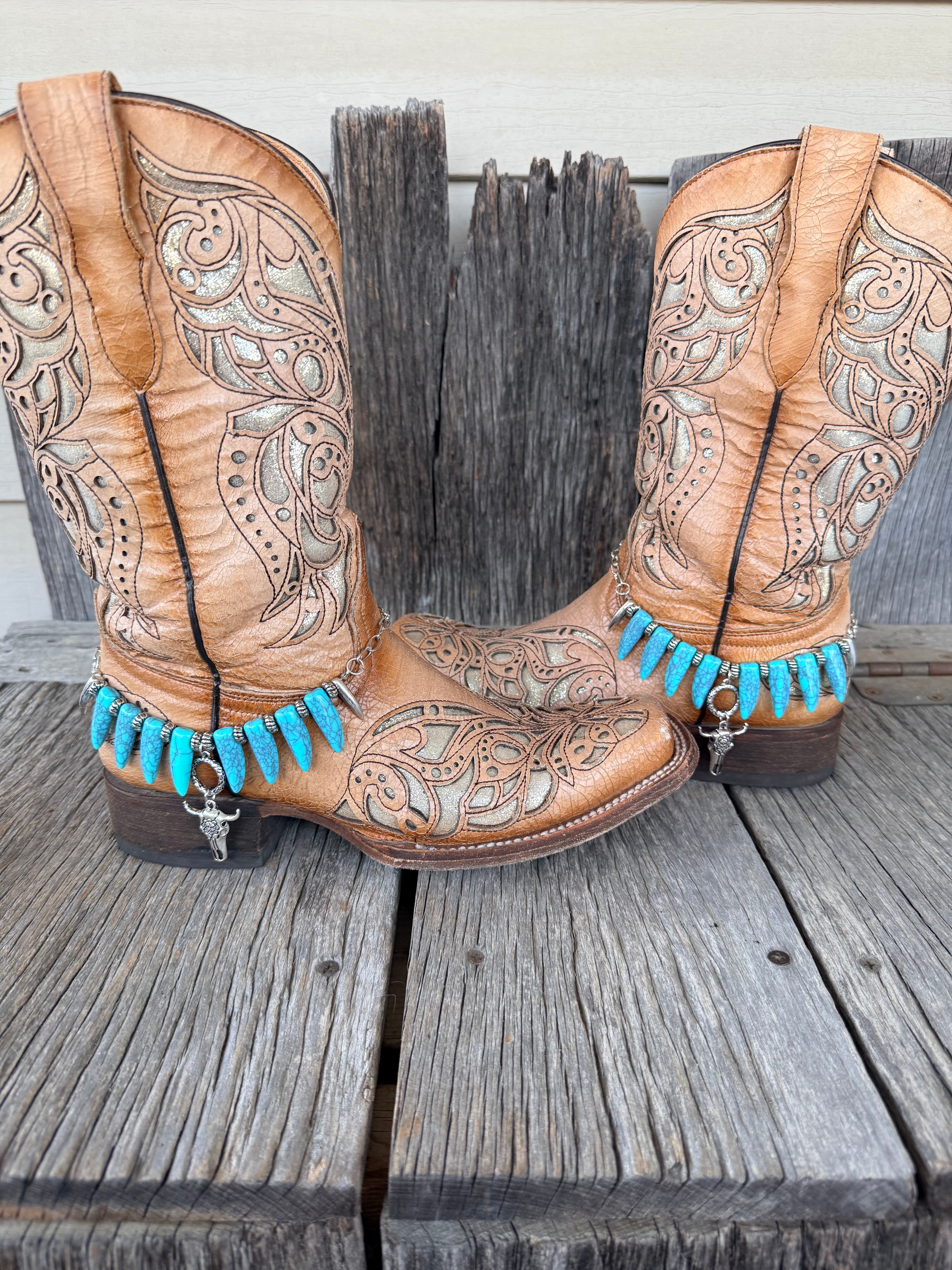 Turquoise coyote tooth and bull skull boot bracelet worn on tan tooled leather cowboy boots, full pair view
