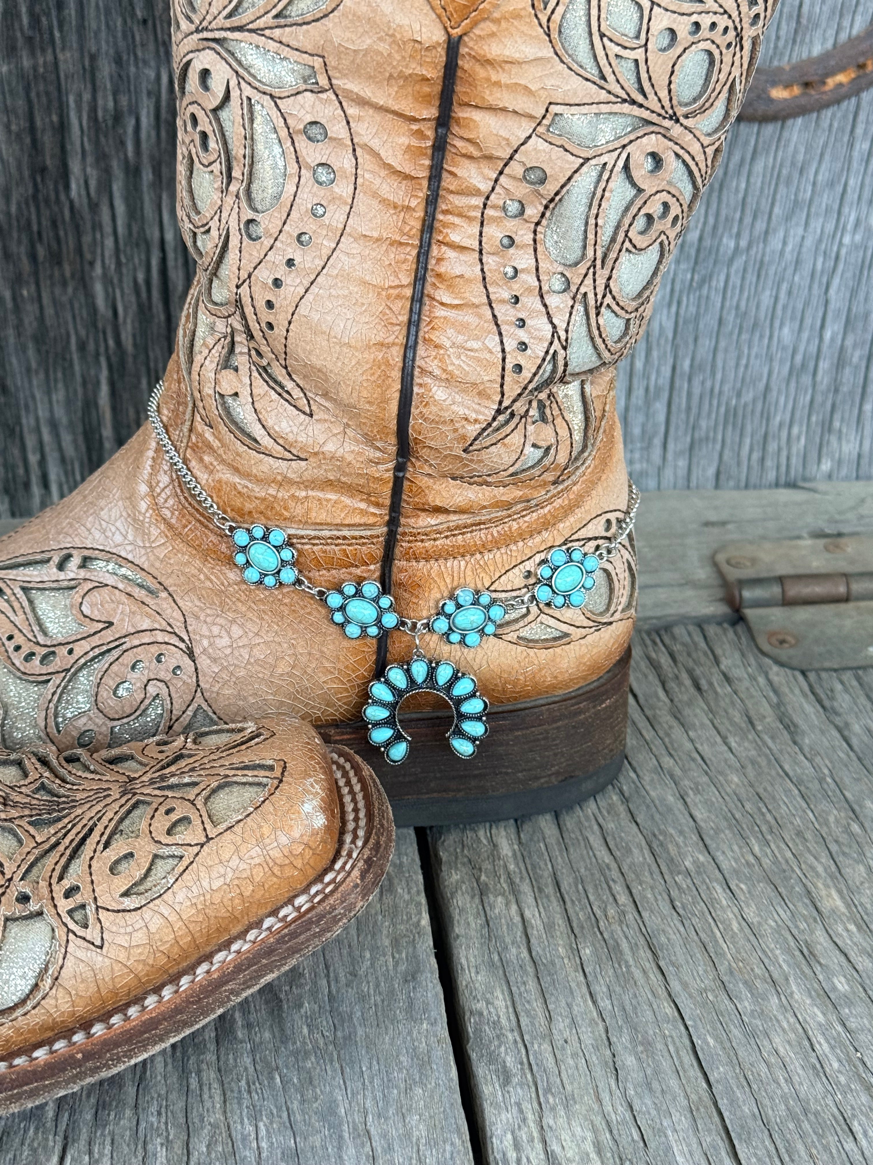 Side view of turquoise cluster rosette boot bracelet chain draped along tan cowboy boot shaft

