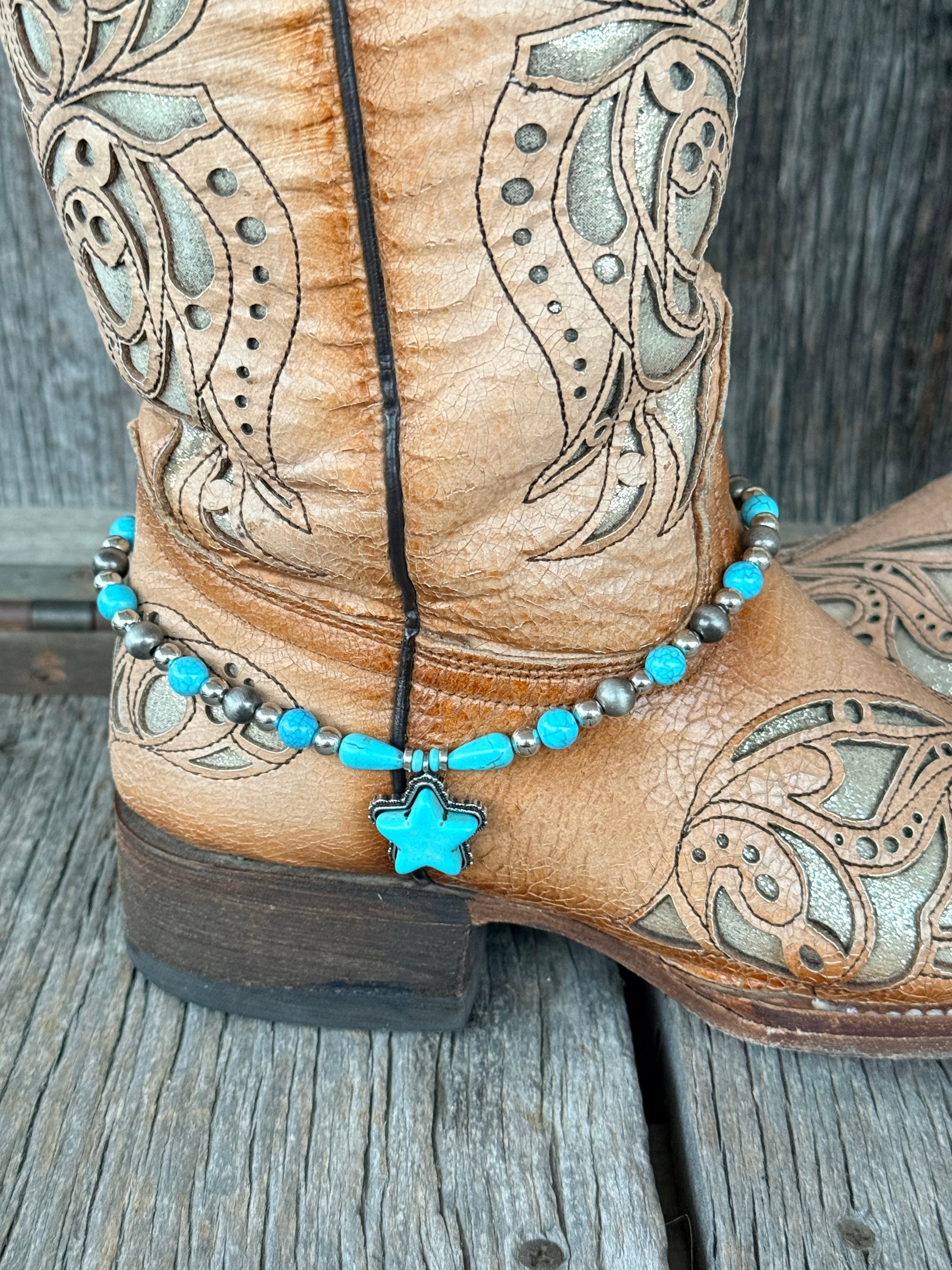 Close-up of gunmetal Navajo pearl and turquoise round bead boot bracelet with turquoise teardrop accents and large turquoise star stone pendant with silver beaded border at heel of tan tooled cowboy boot
