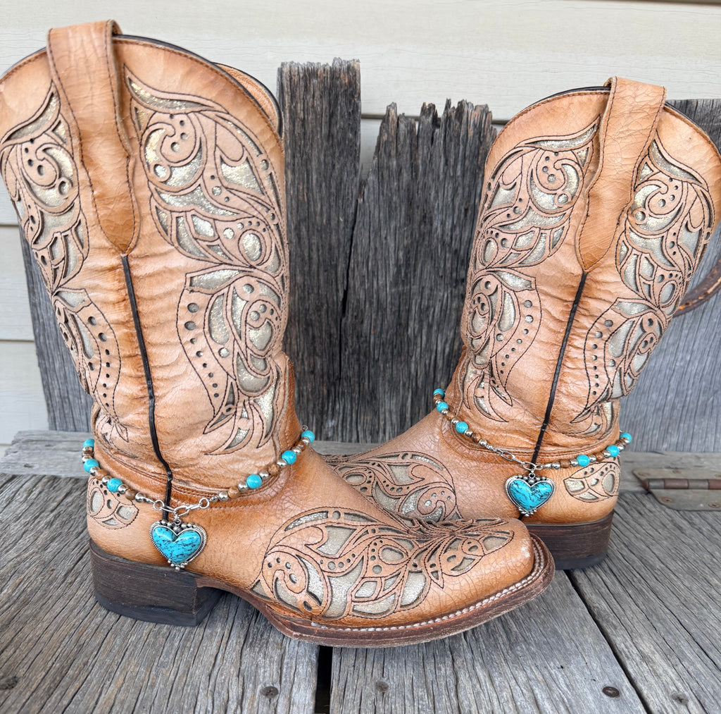 Turquoise heart boot bracelet with turquoise, brown wood and silver beads worn on tan tooled leather cowboy boots, full pair view
