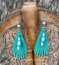 A pair of turquoise leather fringe dangle earrings with silver and light blue beads,
