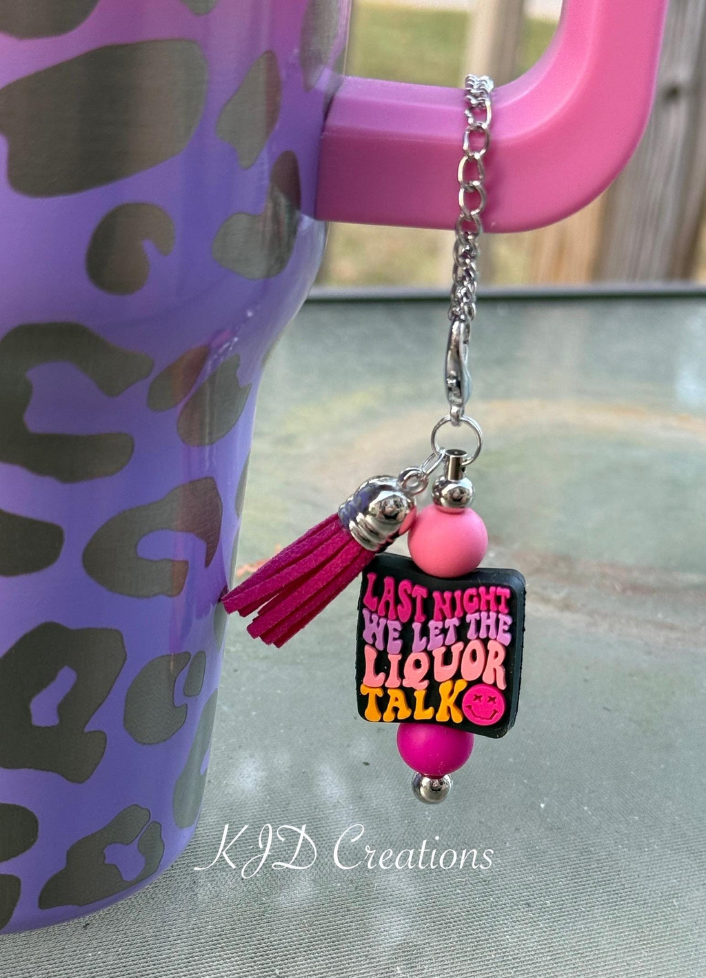 Liquor Talk country music tumbler charm clipped to a purple leopard print insulated cup handle — pink silicone beads with hot pink tassel