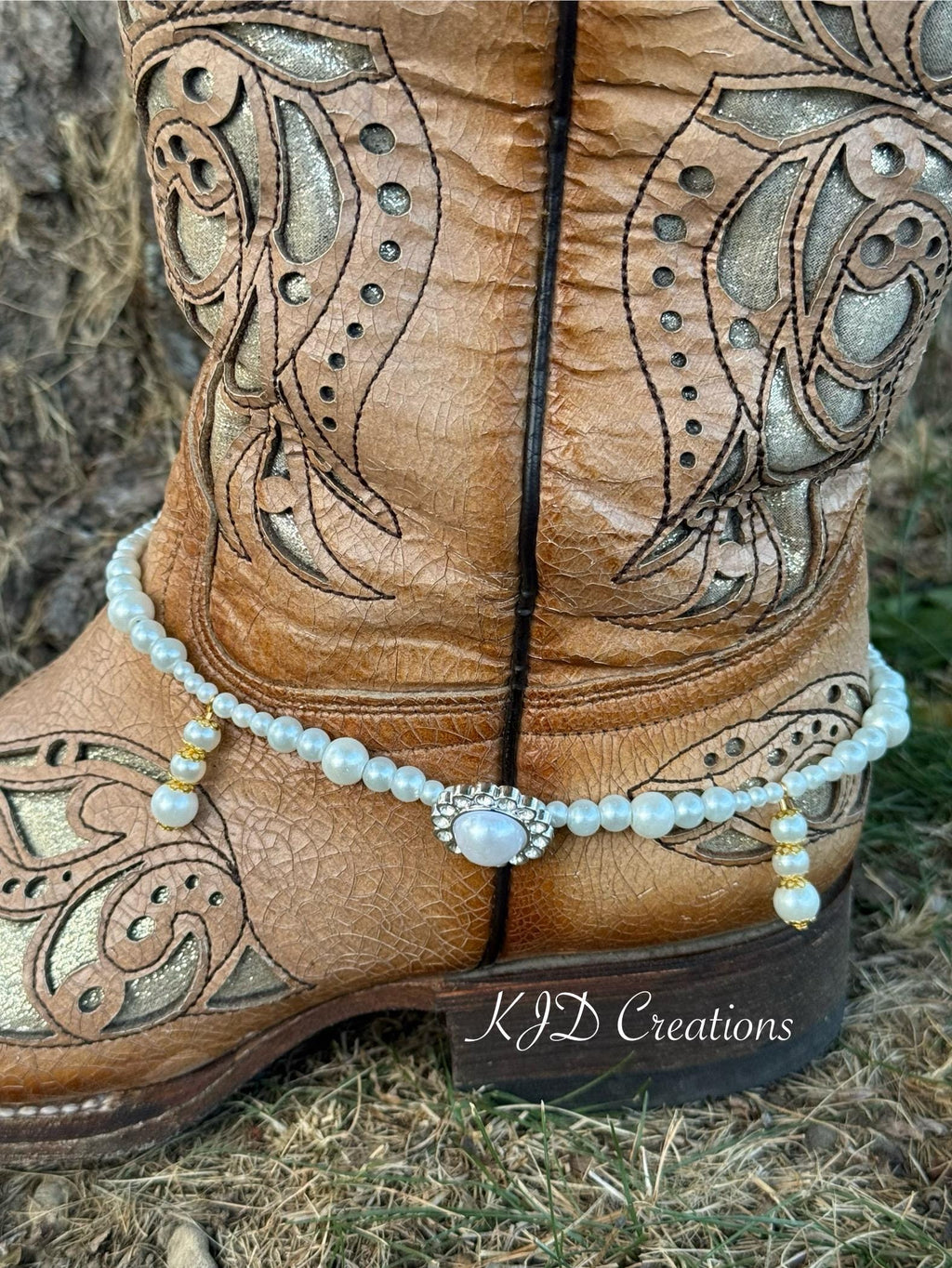 Close-up of pearl beaded boot bracelet with rhinestone and pearl oval concho centerpiece on tan tooled leather cowboy boot, bridal Western wedding boot jewelry