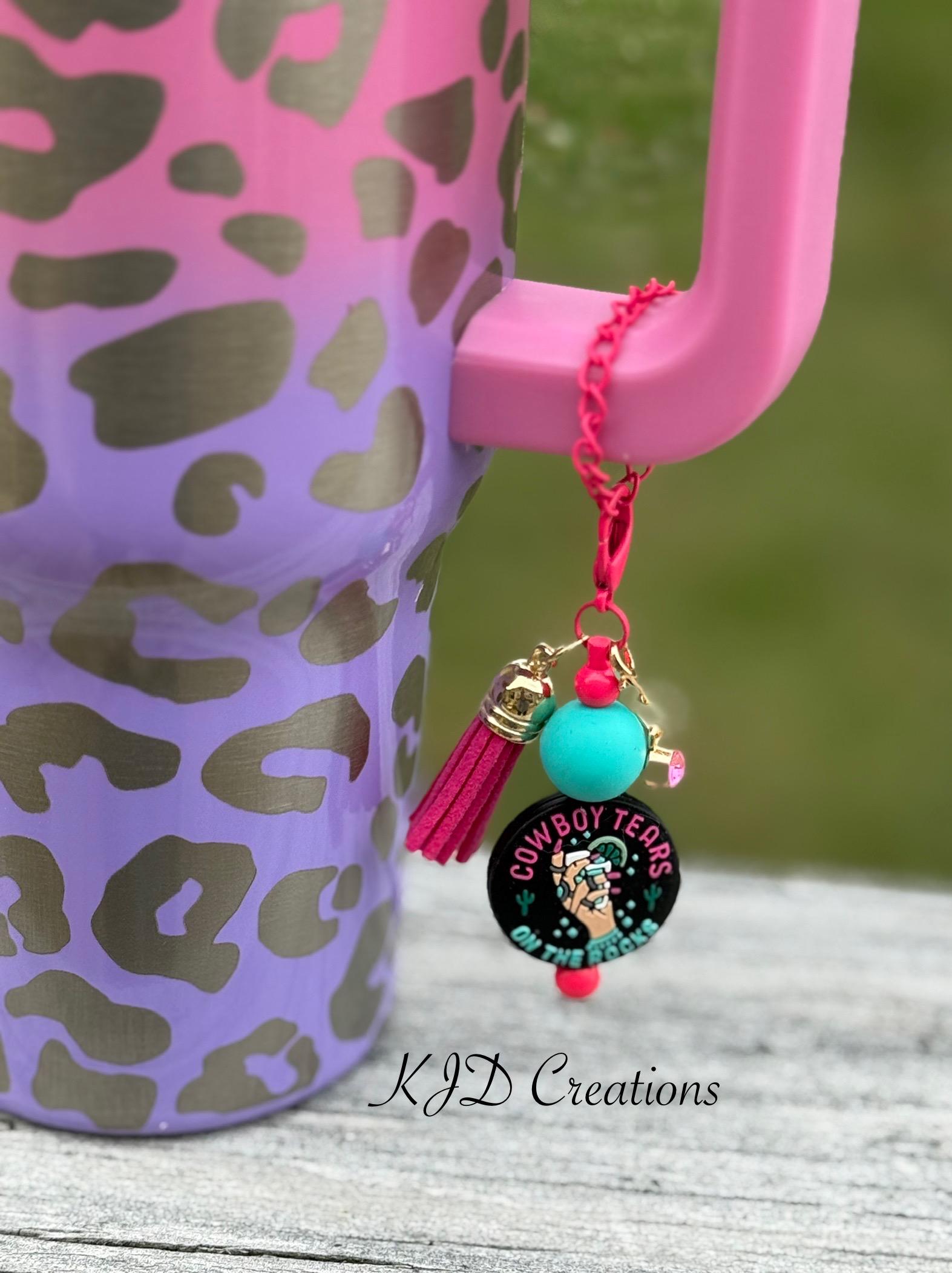 Cowboy Tears Western tumbler cup handle charm clipped to a leopard print insulated tumbler — black charm with teal bead and pink tassel by KJD Creations