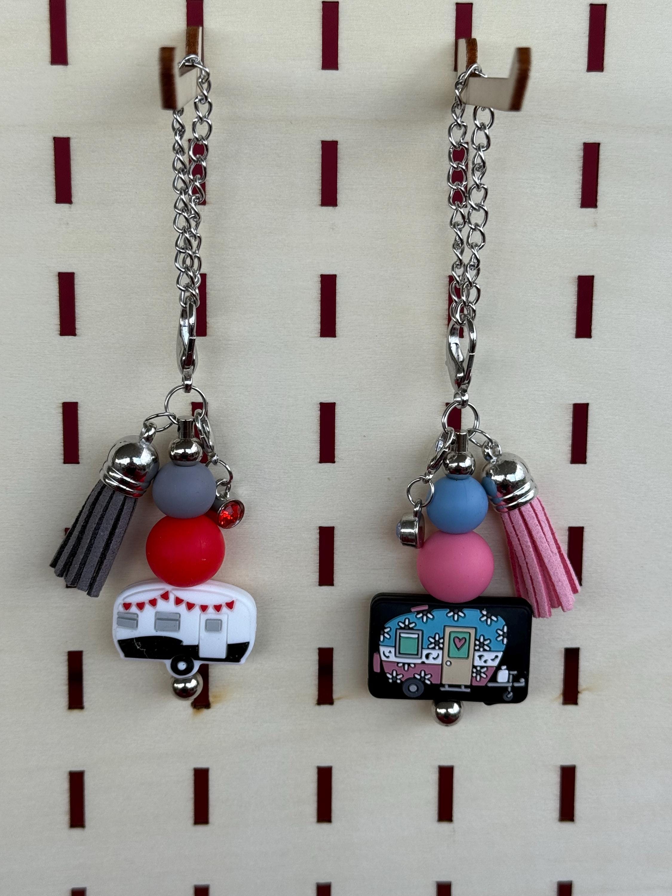 A pair of dangle cup charms displayed on a pegboard. Happy RV Retro Camper