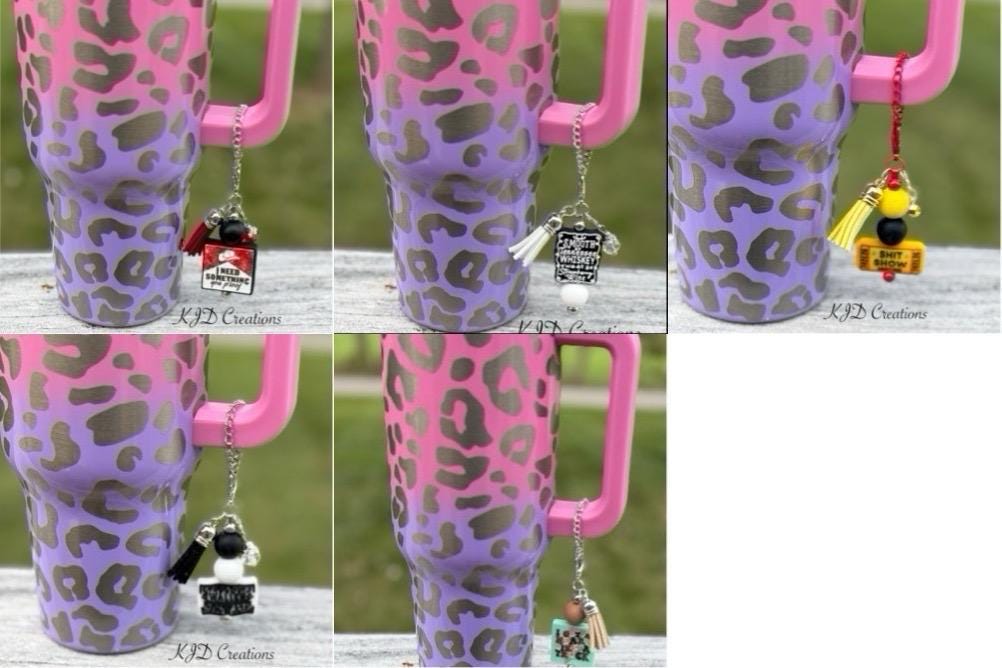Five country music tumbler cup handle charms clipped to a pink and purple leopard print insulated tumbler — You Proof, Whiskey, Admit One, Country Singer, and Truck 