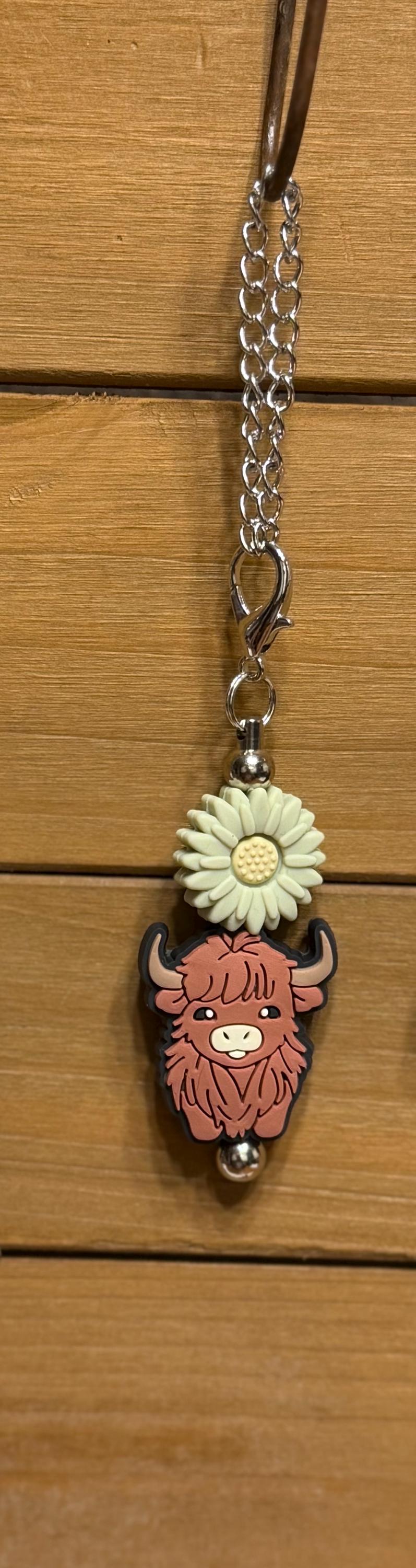 Green Daisy highland cow tumbler dangle charm close-up — silver chain with green daisy silicone bead and pink highland cow charm on dark background by KJD Creations