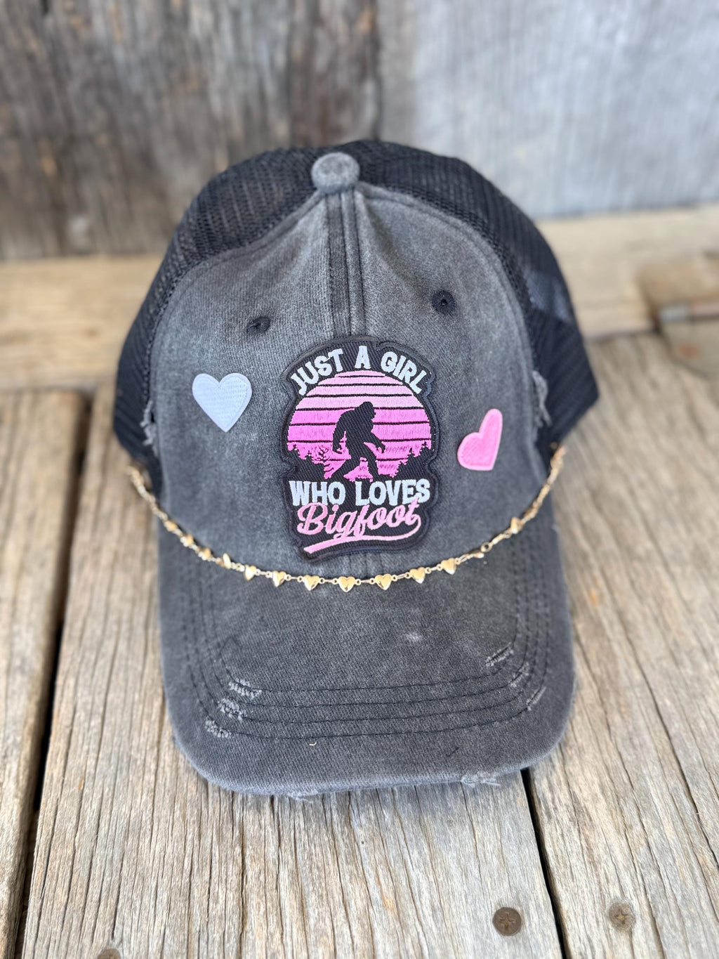 "Just A Girl Who Loves Bigfoot" Black Distressed Ponytail Trucker Hat | Bigfoot Patch & Gold Heart Hat Chain