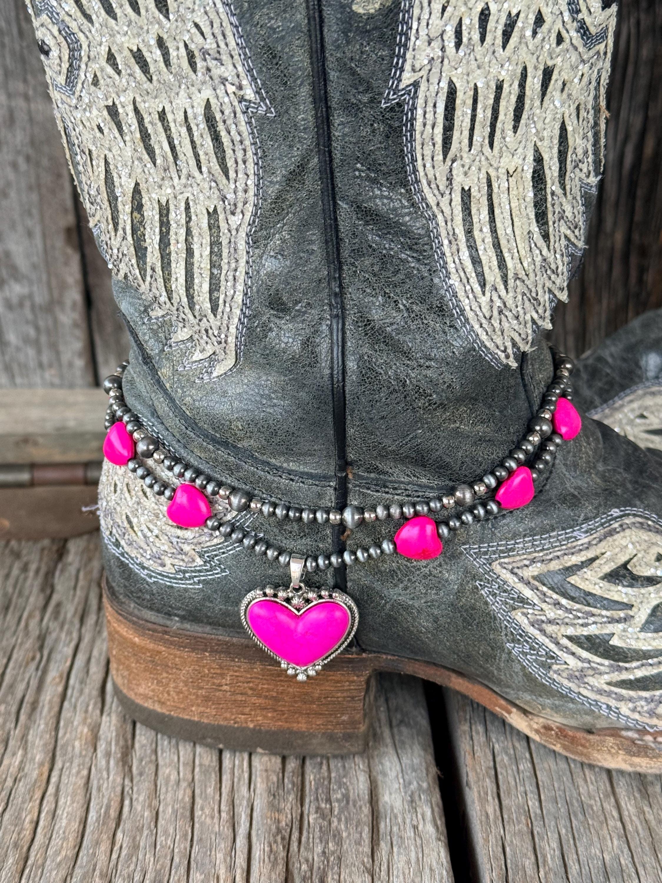Close-up of double-strand silver and hot pink beaded boot bracelet on black angel wing cowboy boot with pink enamel heart charm pendant