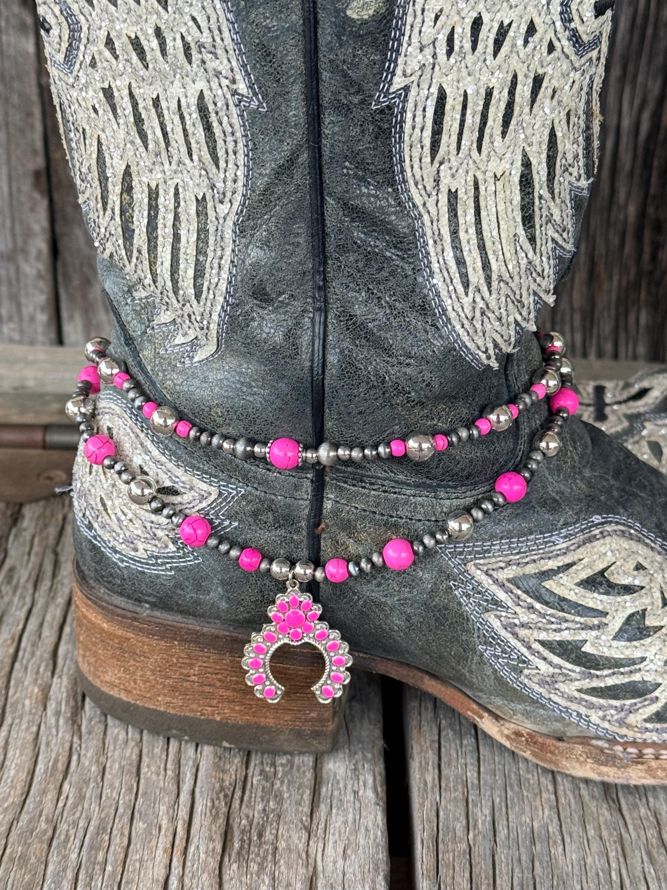 Close-up of double-strand pink and silver beaded boot bracelet on black angel wing cowboy boot with pink squash blossom charm pendant