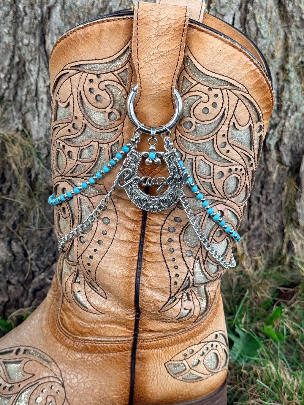 Front view of tan tooled laser-cut cowboy boot with two-strand turquoise bead and silver chain lei boot bracelet and large silver horseshoe cowgirl charm pendant, Western boho boot jewelry