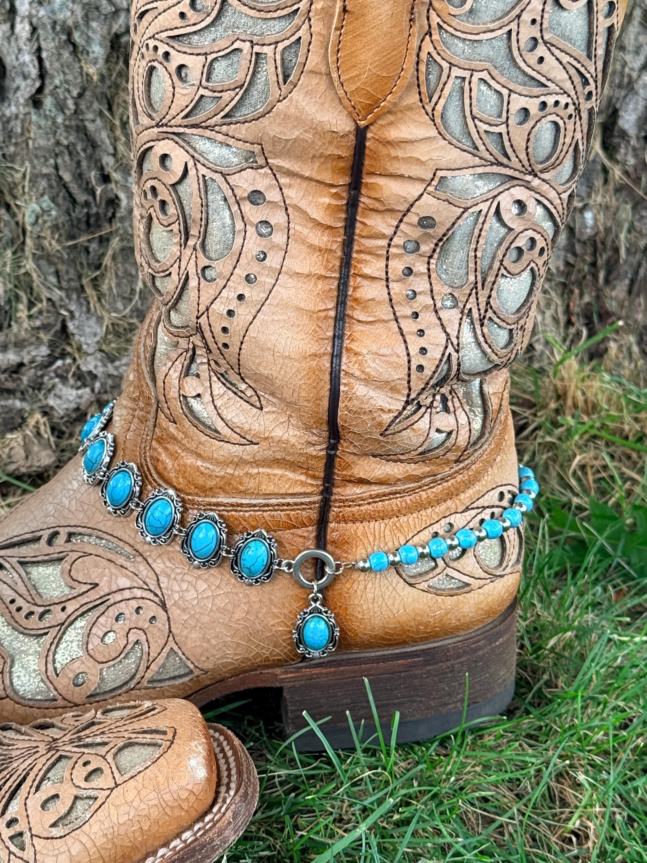 Close-up of tan tooled laser-cut cowboy boot ankle with two-strand boot bracelet featuring linked silver oval turquoise concho strand, turquoise bead strand, and single oval turquoise drop charm pendant