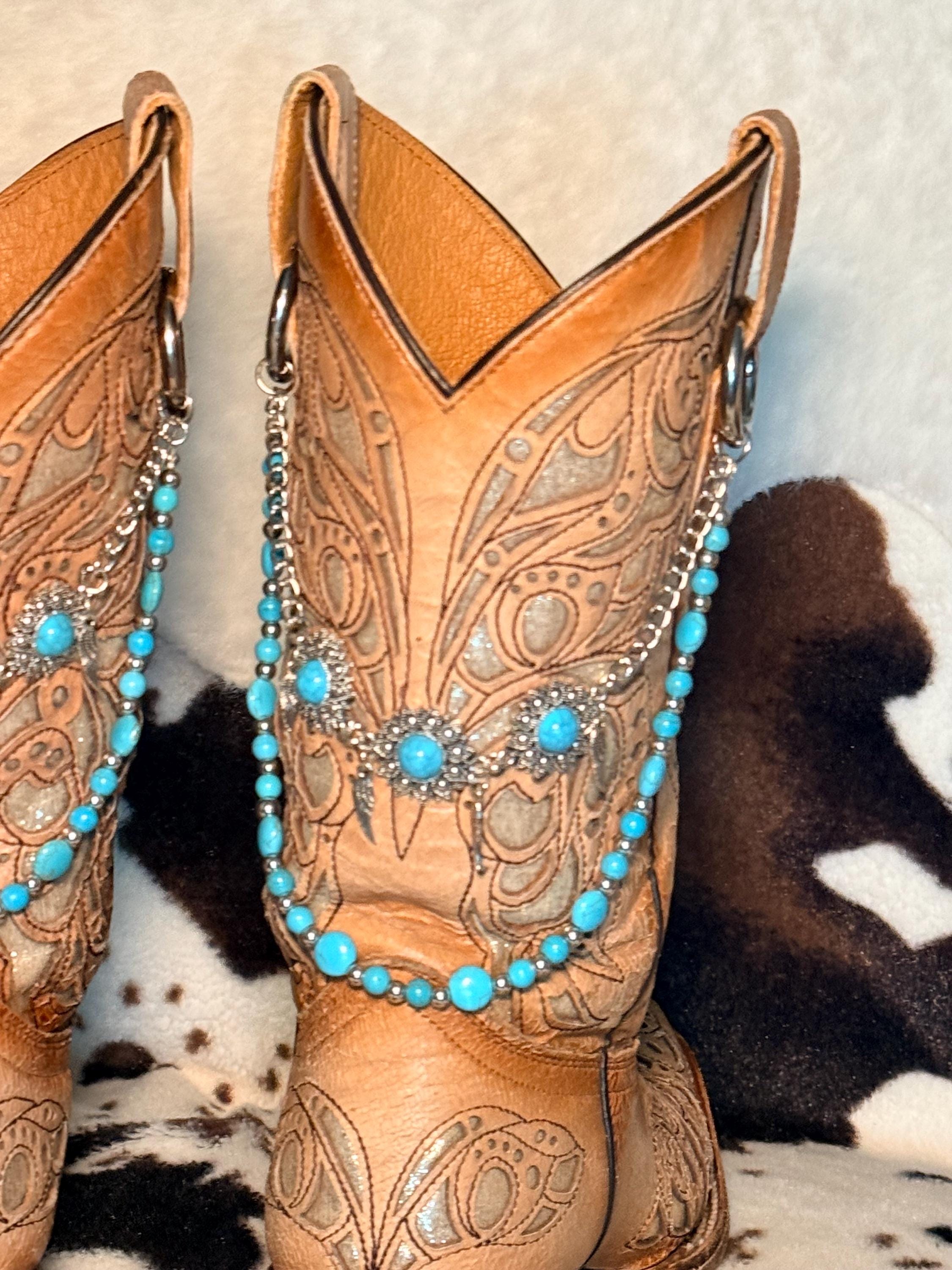 Tan tooled leather cowboy boots boot shaft with turquoise bead and silver spacer bead boot bracelet chain featuring large silver filigree flower concho centerpiece with three turquoise cabochon stones