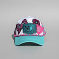 A turquoise and white trucker hat with decorative embroidered patches, including a checkered bow, flower, and a central Texas-themed patch.